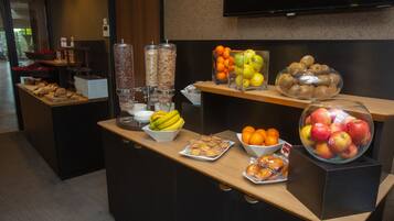 Un buffet proposant une variété de fruits et de pâtisseries.