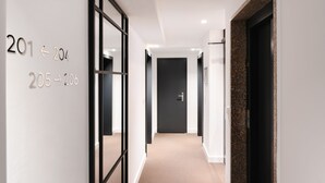Un pasillo moderno con indicaciones que señalan las habitaciones 201, 204, 205 y 206.