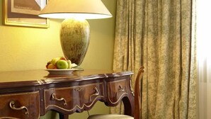 Un escritorio de madera con una lámpara, un plato de fruta y una silla.