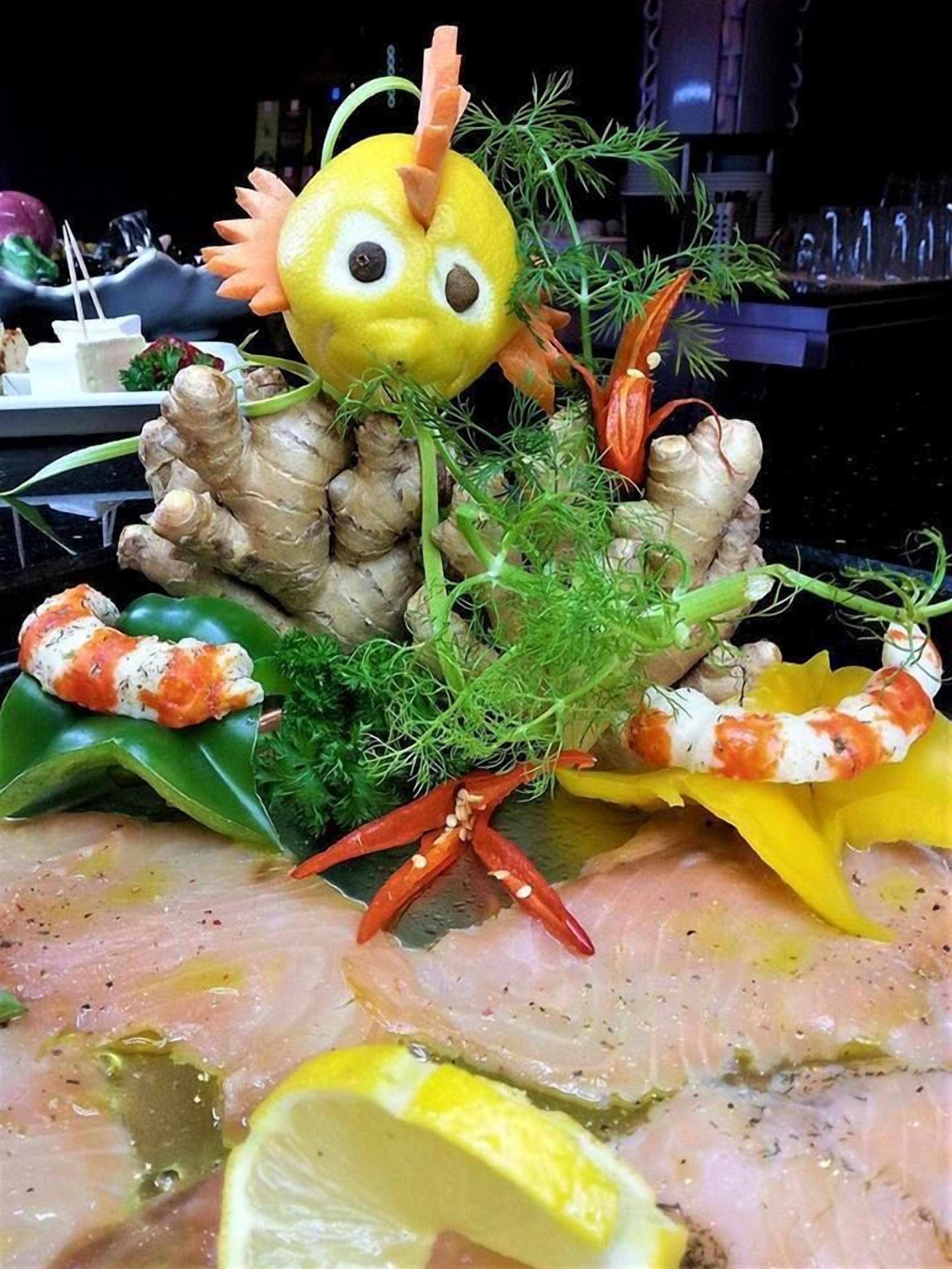 Uma mesa com diversos alimentos, incluindo gengibre, camarão e rodelas de limão.