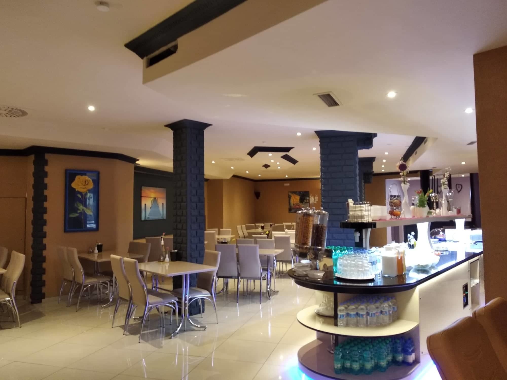 A hotel lobby with a central bar area, seating arrangements, and decorative elements.