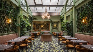 Un restaurant doté d’un bar central, de banquettes et de tables.