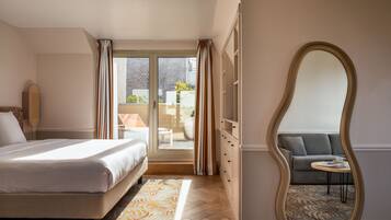 Une chambre d’hôtel avec un lit, un grand miroir, un canapé et une vue sur l’extérieur.