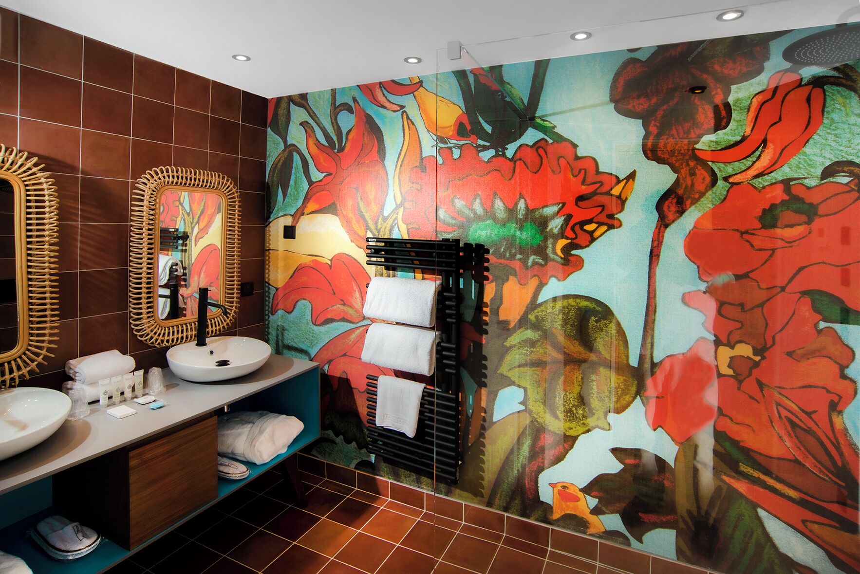 A bathroom with two sinks, a large mirror, and a vibrant floral mural.