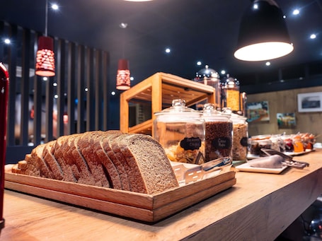 A bakery display with sliced bread and jars of spreads.. ibis Portsmouth Centre