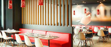 Interior de restaurante con asientos rojos, listones de madera y faroles rojos colgantes.