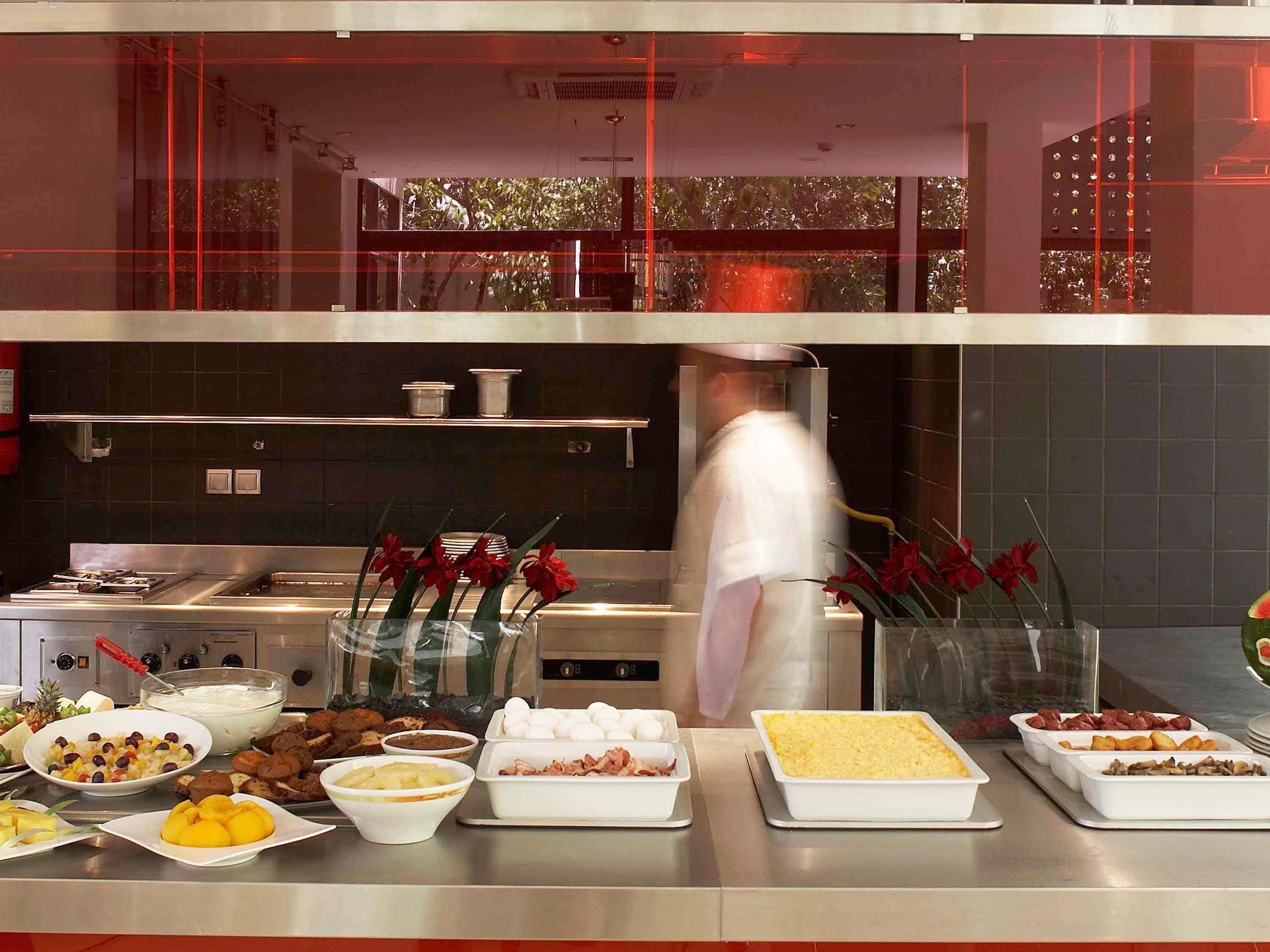 A commercial kitchen with various food items displayed on the counter.