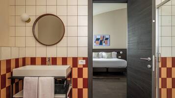 A bathroom with a sink, mirror, and towel rack.