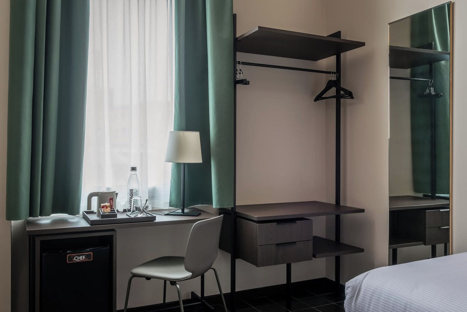Una habitación de hotel con escritorio, silla y cama.
