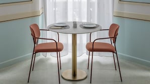 A room with a round table, two chairs, a large window with sheer curtains, and wall-mounted lamps. - BYPILLOW Grand Central (Padova)
