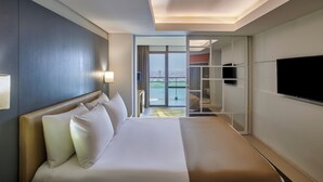 A hotel room with a large bed, a TV on the wall, and a view of the city through the window. - Holiday Inn Cairo Maadi by IHG (Cairo)