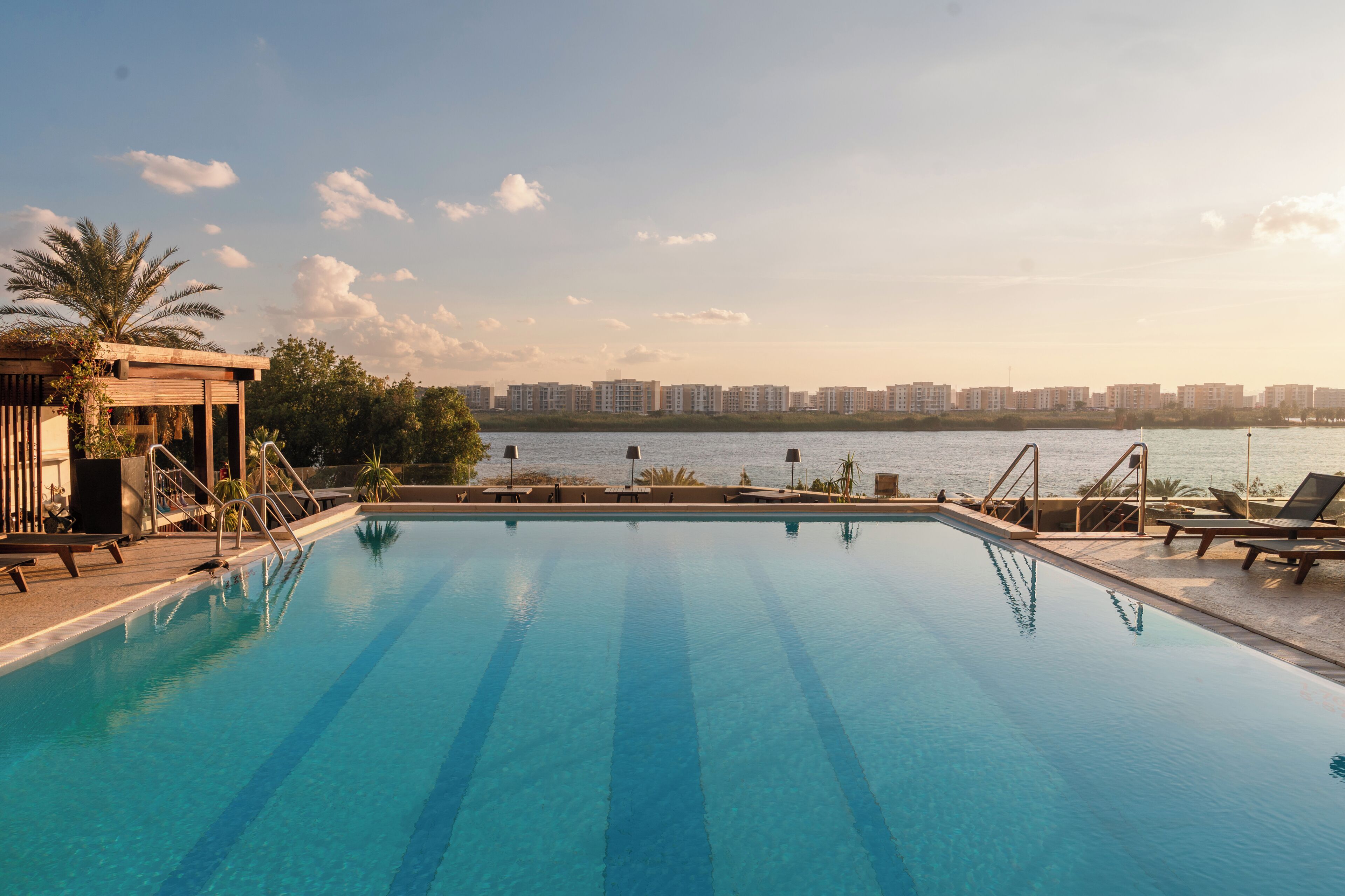 A swimming pool with a view of a city skyline and a body of water.