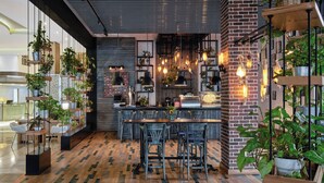 A modern kitchen with a brick wall, hanging plants, and a wooden dining area. - Holiday Inn Cairo Maadi by IHG (Cairo)