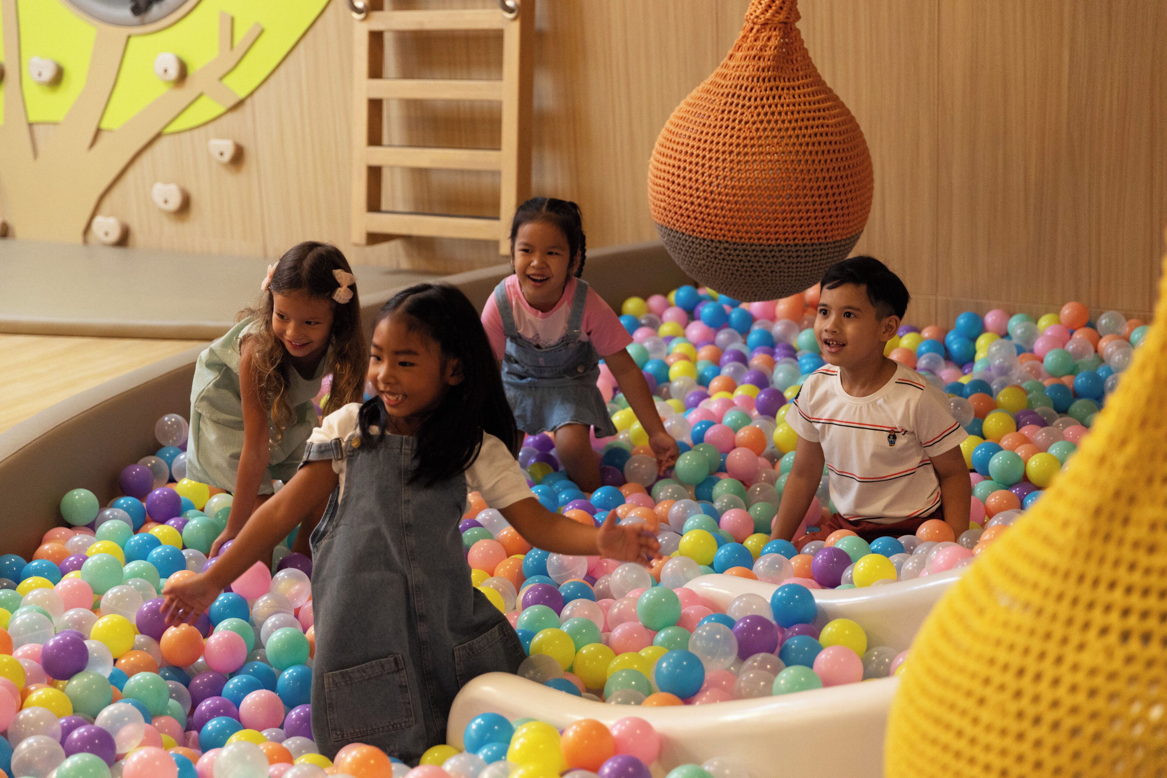 Children playing in a ball pit filled with colorful balls.