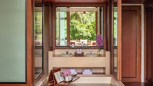 Une salle de bain dotée d’une grande fenêtre, de deux lavabos et d’un espace coiffeuse.