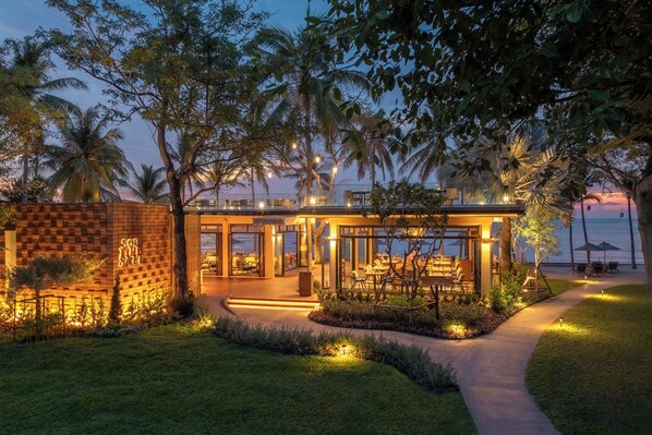 Relax in our spacious outdoor area with a seating arrangement surrounded by palm trees and a pathway.