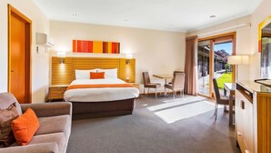 A hotel room with a large bed, a desk, a chair, and a small table. - Julie-Anna Inn, Bendigo (Bendigo)