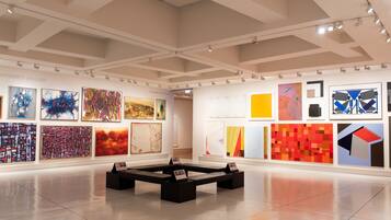 An art gallery with various abstract paintings on display.