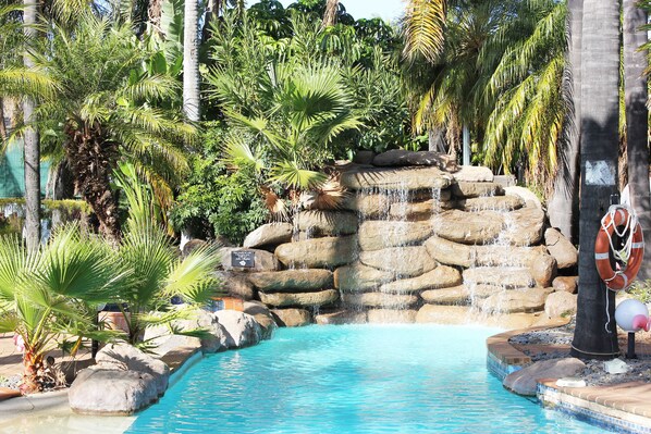 Piscine couverte, piscine extérieure, parasols de plage, chaises longues