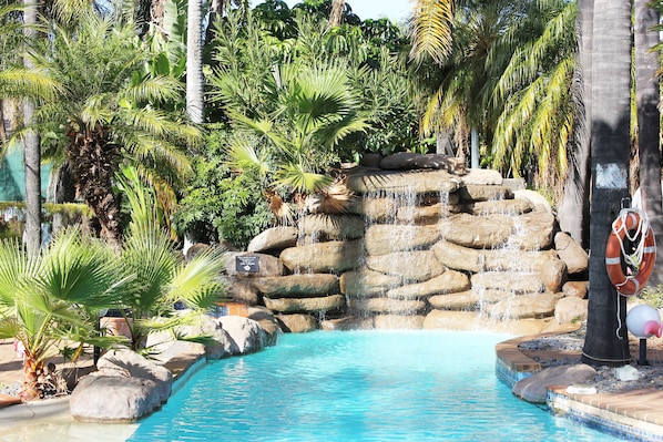 Piscine couverte, piscine extérieure, parasols de plage, chaises longues