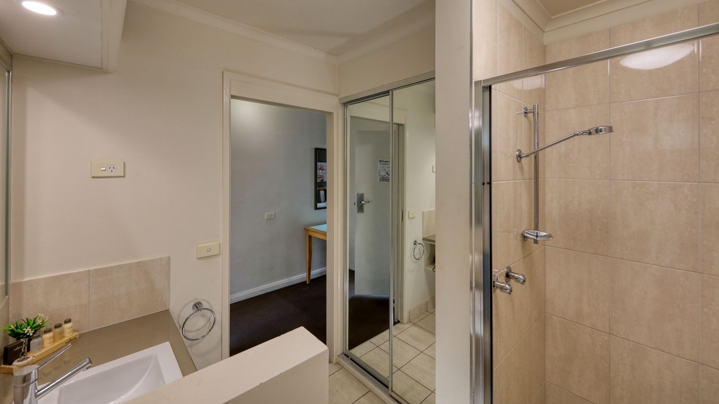 A modern bathroom with a glass-enclosed shower, a bathtub, and a vanity with a mirror.