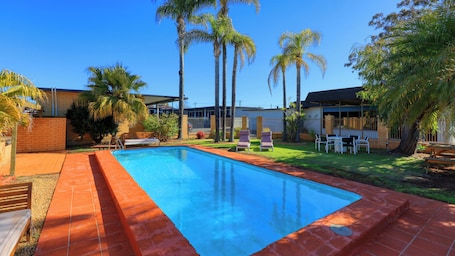 Una piscina al aire libre, sillones reclinables de piscina. Hilltop Motel