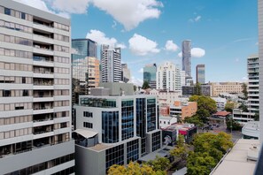 A modern urban skyline with high-rise buildings, including a distinctive cylindrical skyscraper. - Punthill Spring Hill (Spring Hill)