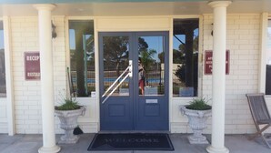 A building entrance with a blue door, a reception sign, and a welcome mat. - Ceduna East West Motel (Ceduna)