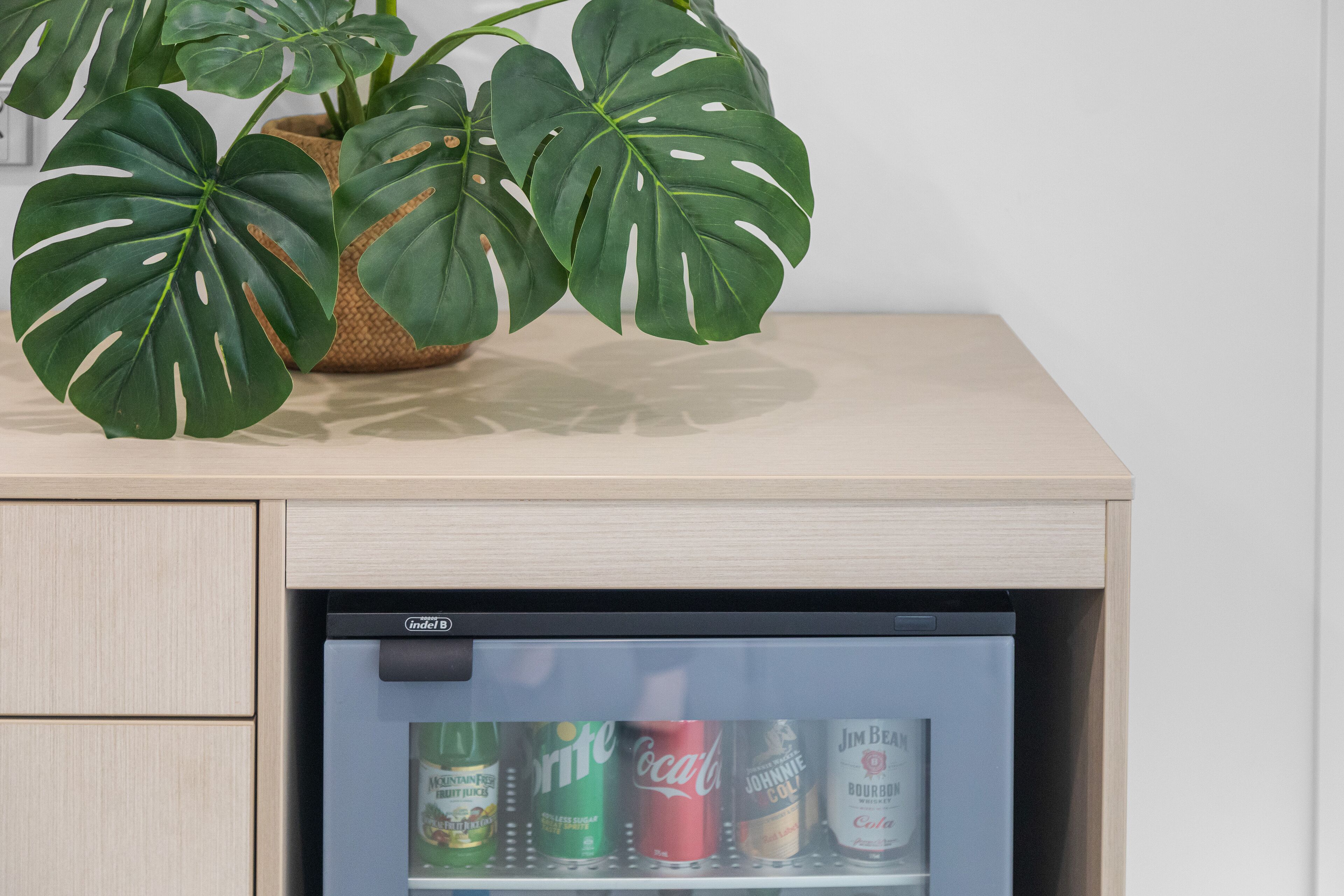 A minibar with a plant and beverages.