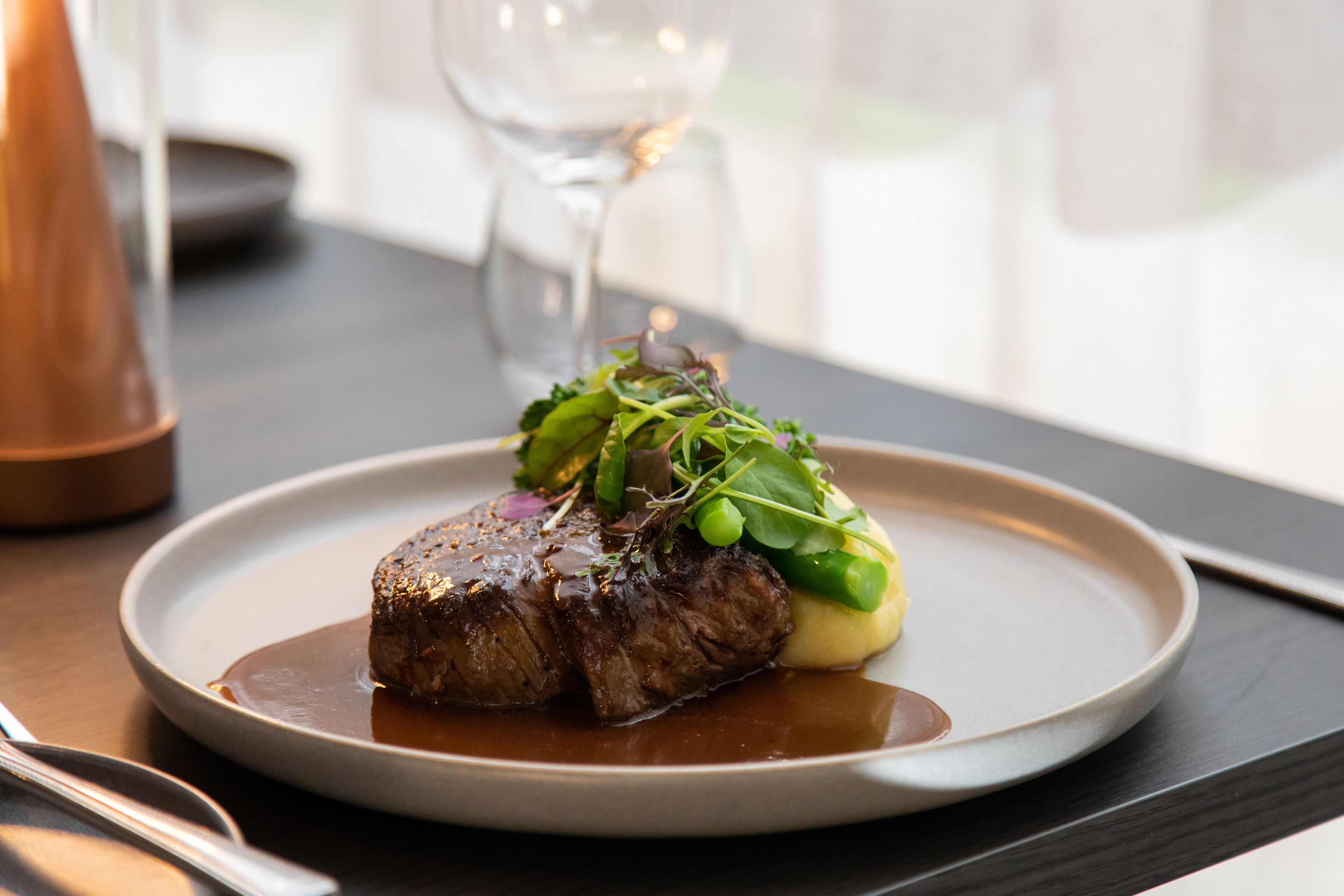 Prato com bife e vegetais sobre uma mesa.
