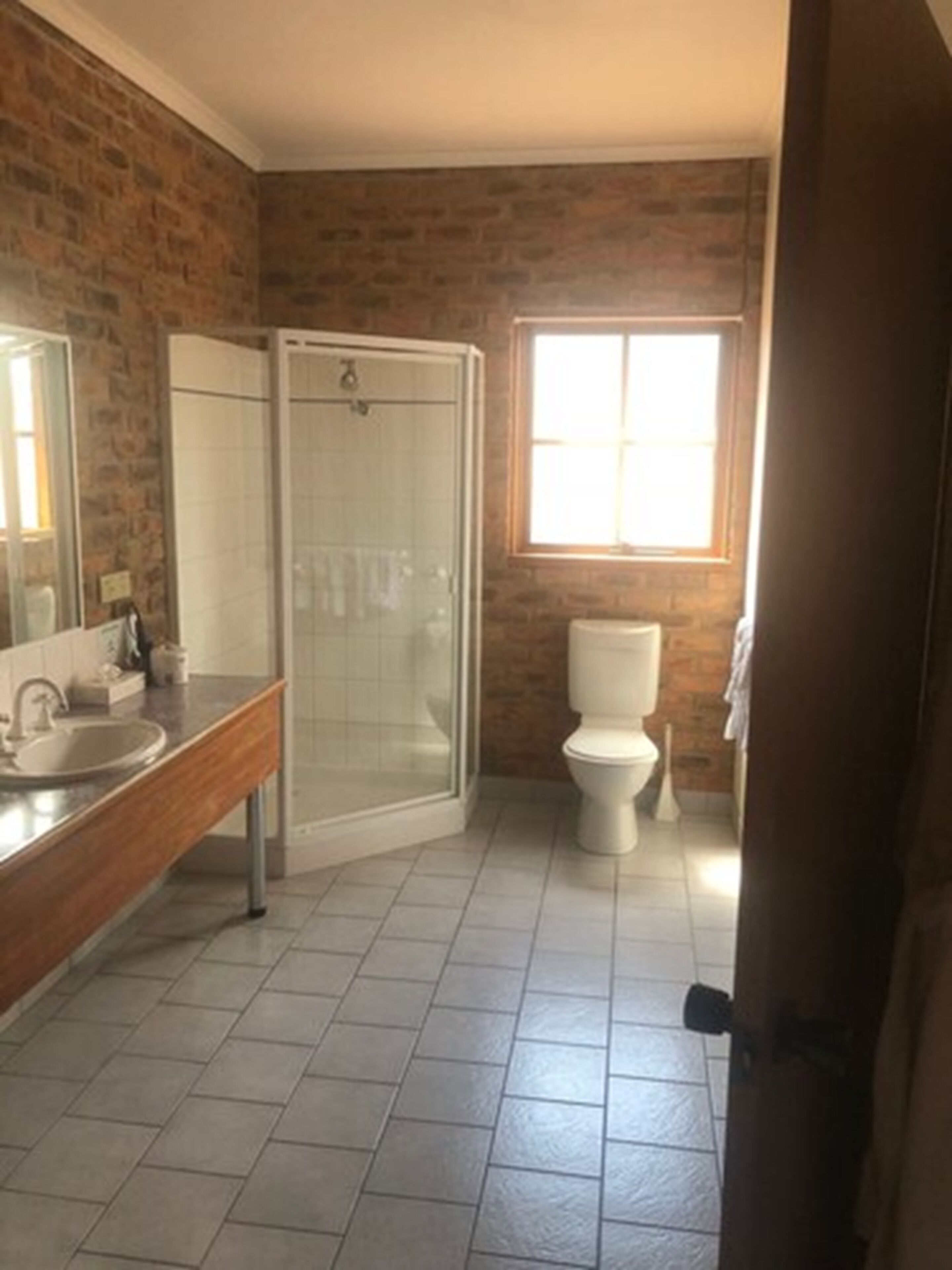 A bathroom with a shower, toilet, and sink.