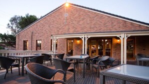 A brick building with outdoor seating and tables. - Mercure Port of Echuca (Echuca)