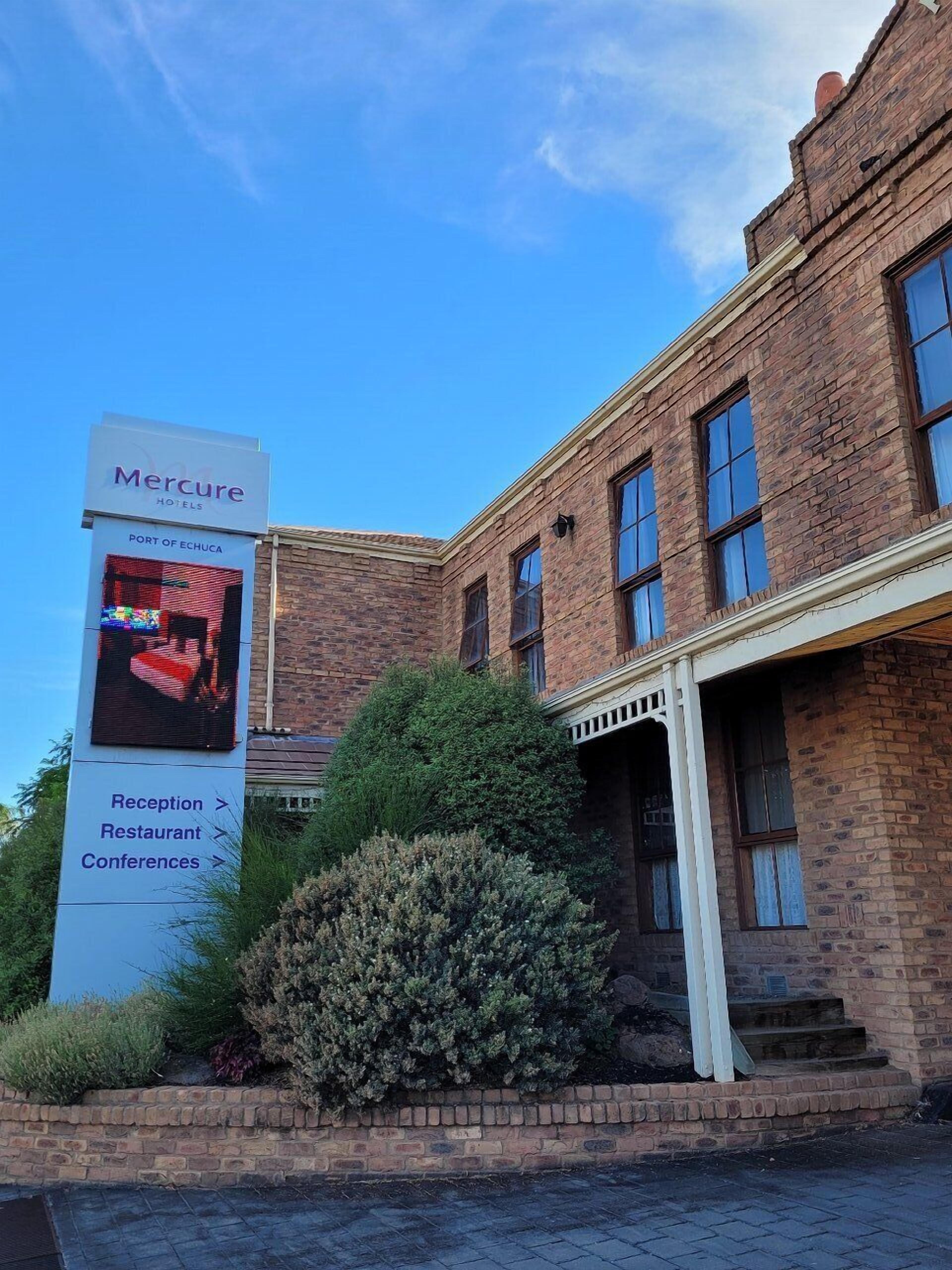 A brick building with a sign for Mercure Hotels, Reception, Restaurant, and Conferences.