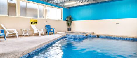 An indoor swimming pool with a blue and beige color scheme, a no running, no diving, and no glass sign, and a 1.5 meters depth marker.