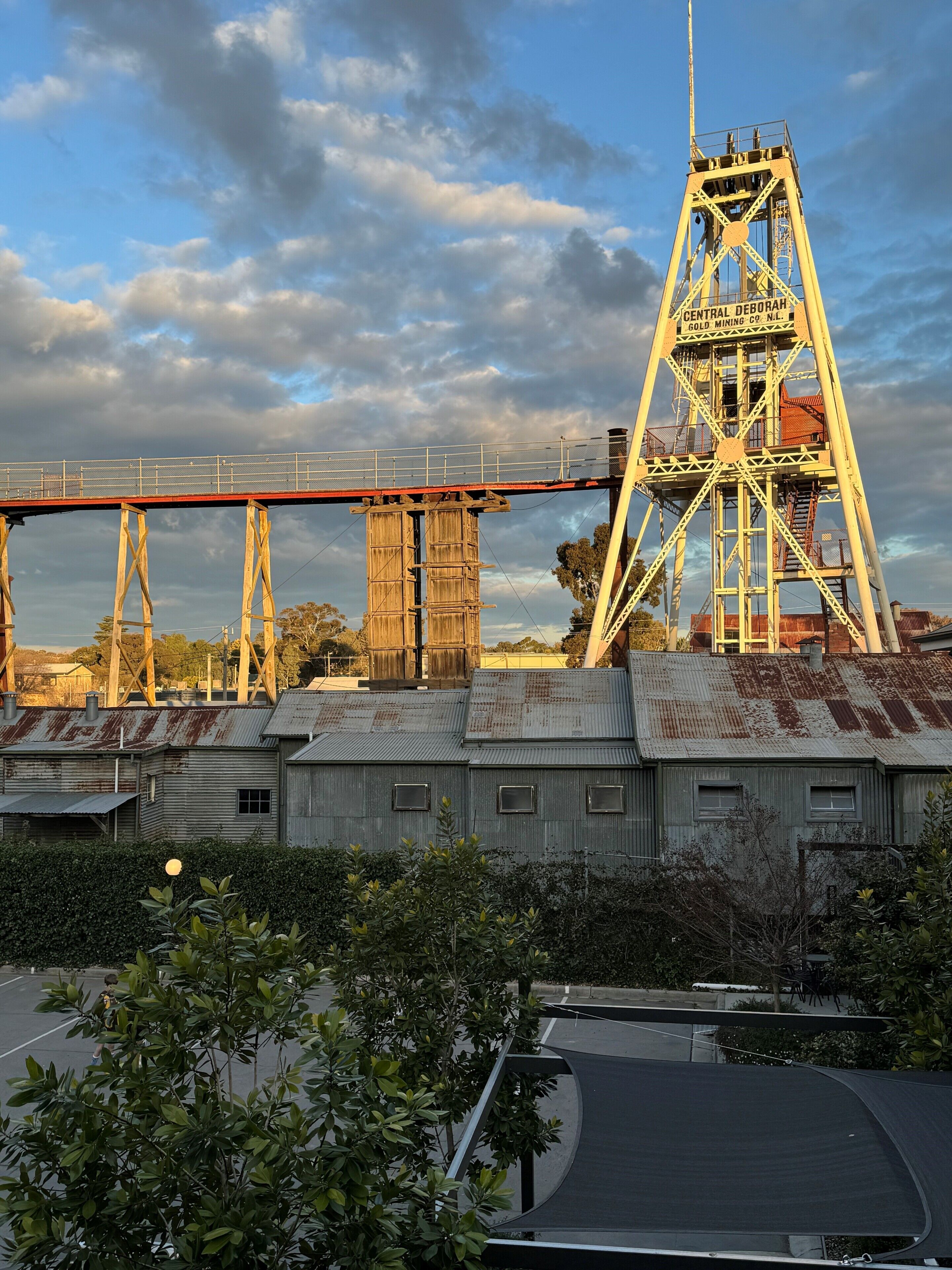 A historic mining structure with a bridge and industrial buildings.