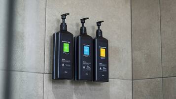 Three black bottles of Outback Essence products on a tiled wall.