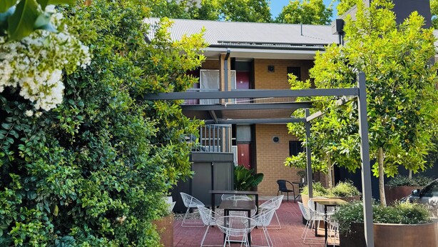 A building with a brick facade, a balcony, and a patio area with outdoor furniture. - Bendigo Central Deborah (Bendigo)
