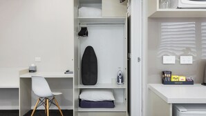 A compact hotel room with a bed, a desk, a chair, and a wardrobe. - Bendigo Central Deborah (Bendigo)