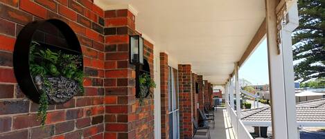 A covered outdoor area with brick walls, potted plants, and outdoor seating.