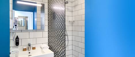 A modern bathroom with a white sink, mirror, and shower.