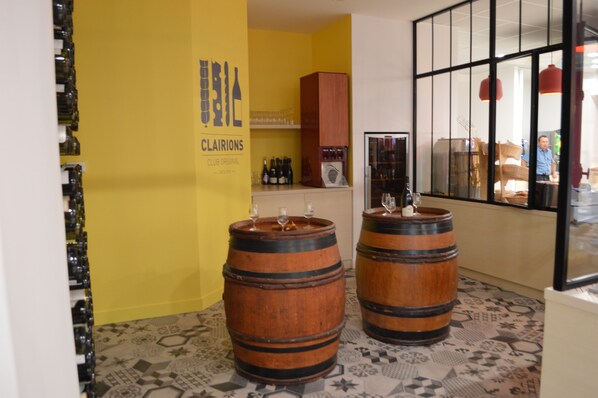 A room with two wooden barrels, a yellow wall with a sign, and a window with a view.