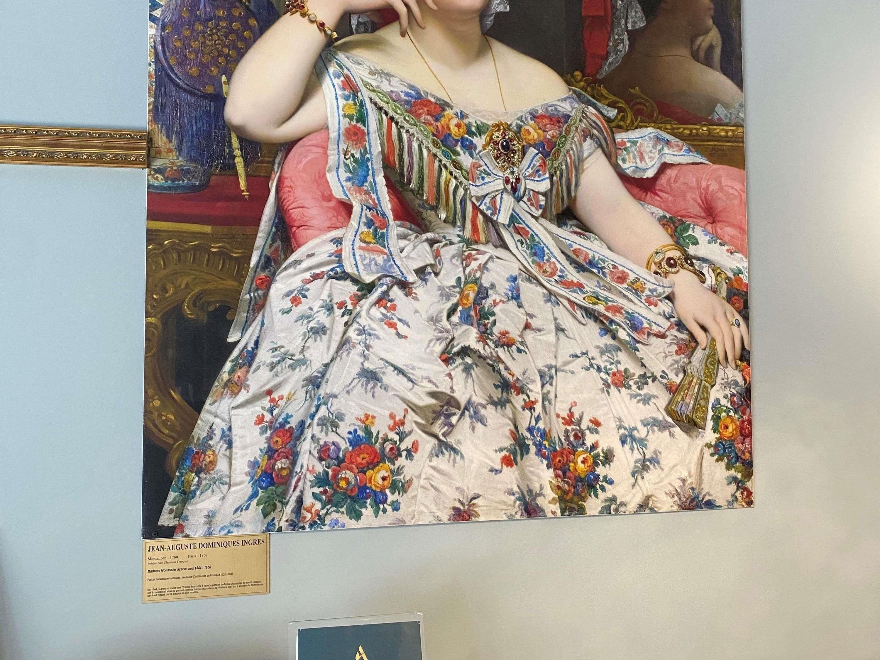 Retrato emoldurado de uma mulher vestindo um vestido com padrão floral detalhado.