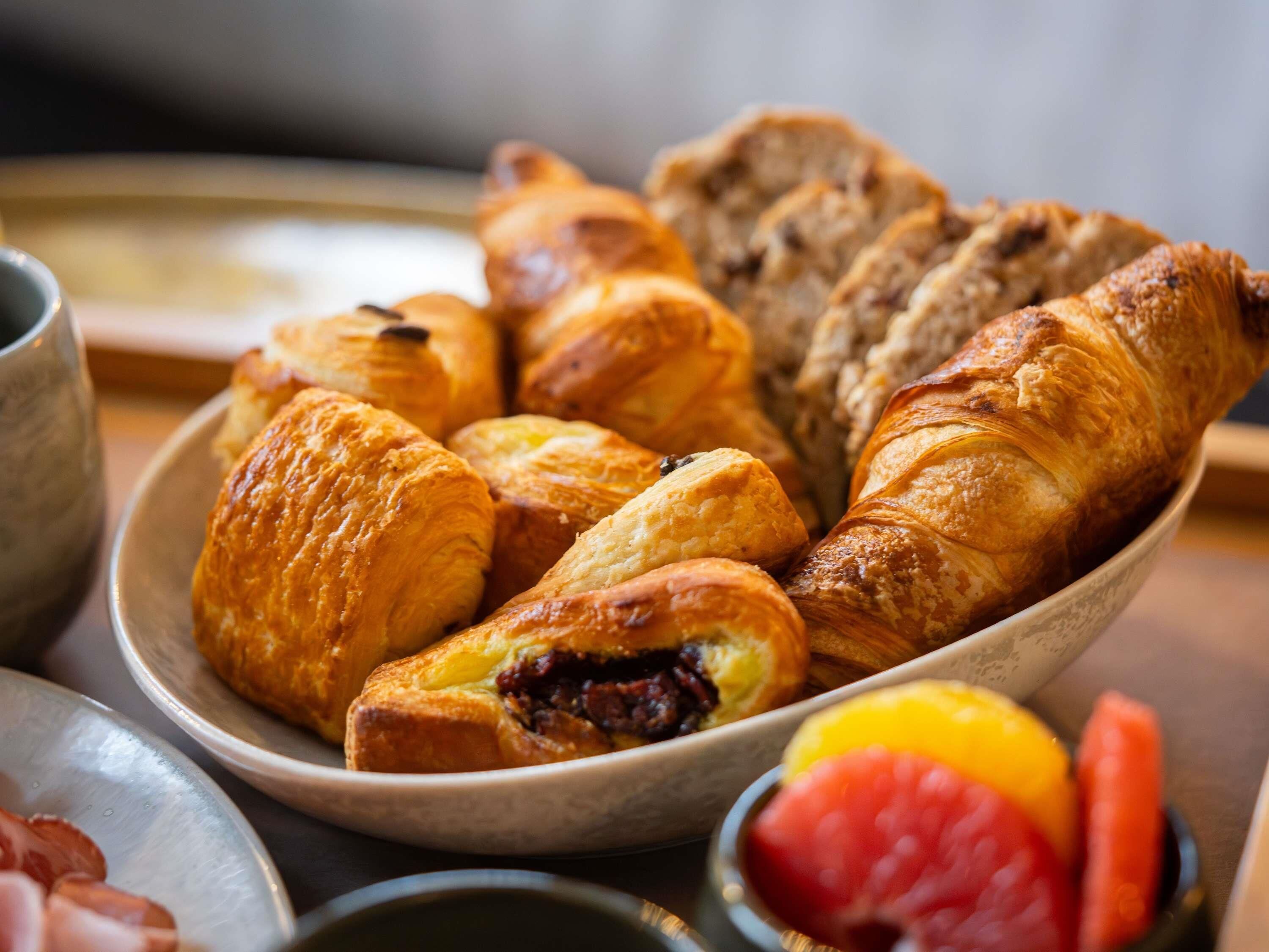 Une variété de pâtisseries et de fruits sont disposés sur une table.