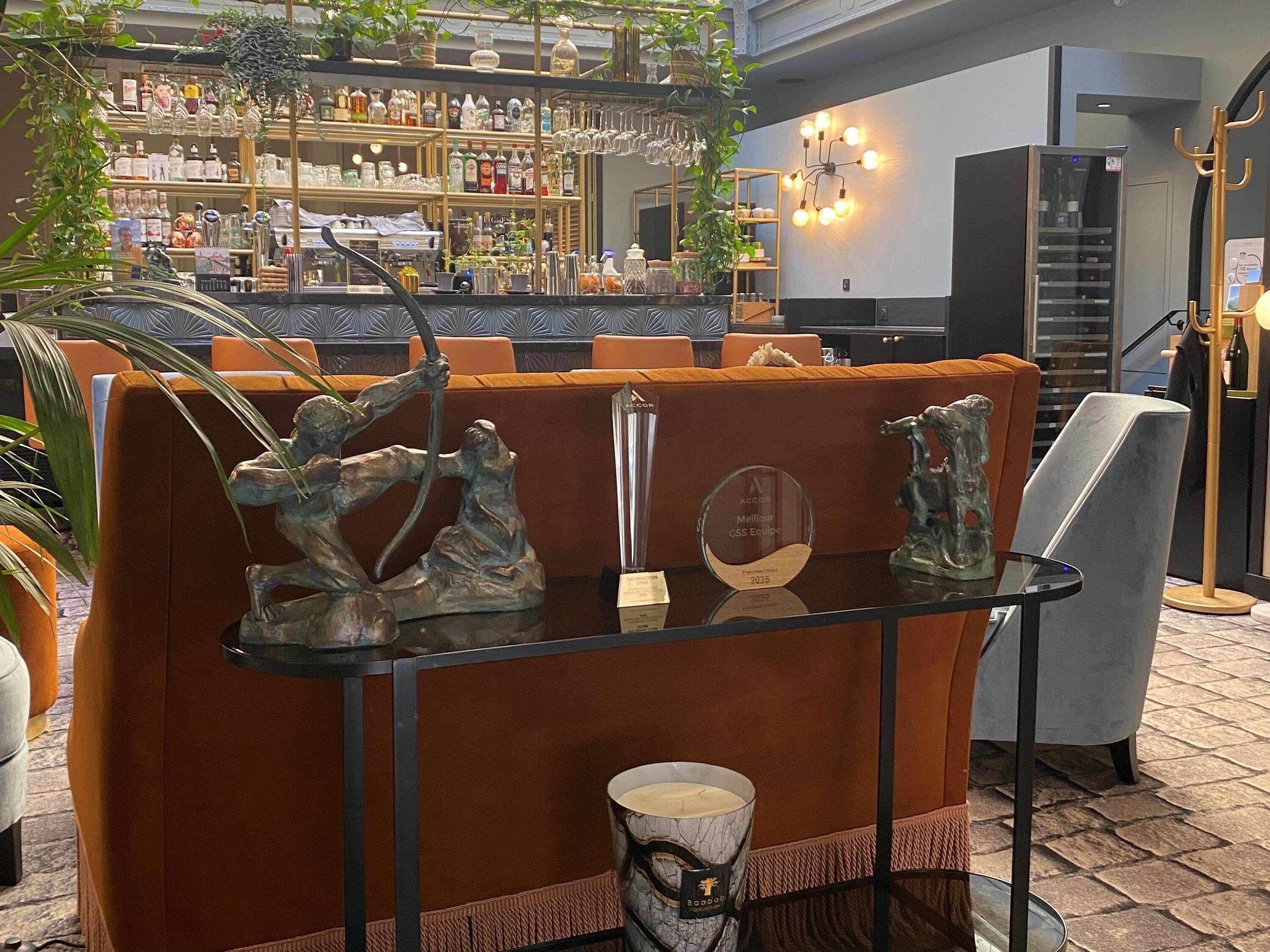 A bar area with seating, a display of awards, and a variety of bottles and glasses.
