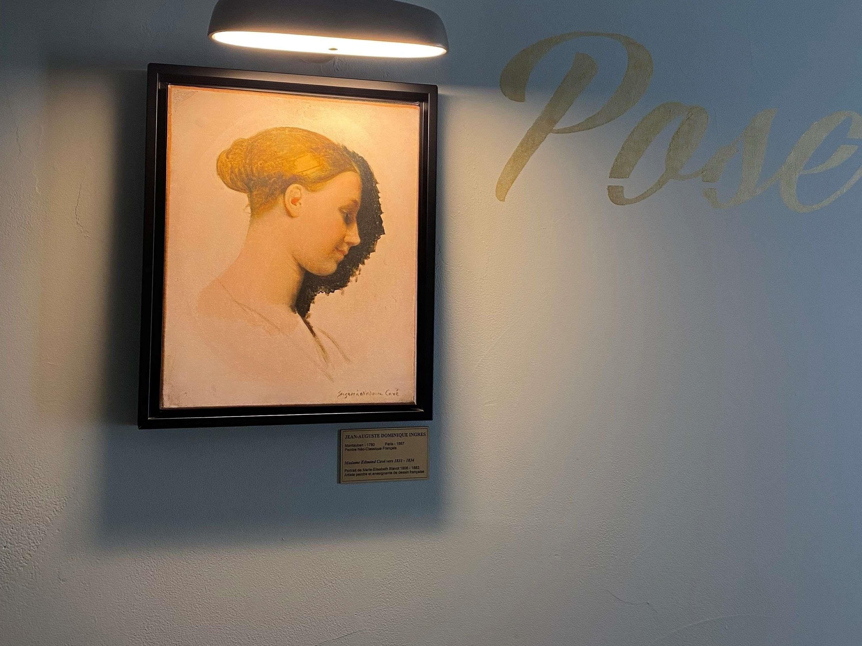 A framed portrait on a wall with a plaque below it.