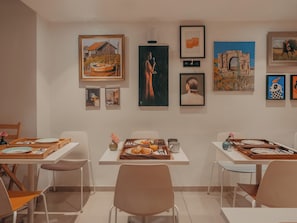 A dining area with tables set for two, each with a tray of food and cutlery. - Hôtel Vendome Saint Germain (Paris)
