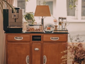 A kitchenette with a coffee machine, a lamp, a coffee pot, and a plant. - Hôtel Vendome Saint Germain (Paris)