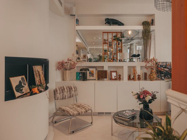 A modern living room with a sofa, a coffee table, and a bookshelf. - Hôtel Vendome Saint Germain (Paris)