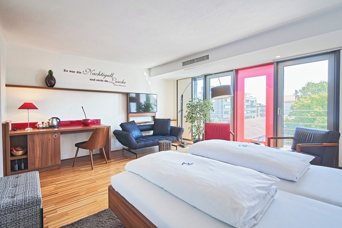 Una habitación de hotel moderna con cama, escritorio y zona de estar.