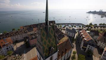 Eine Vogelperspektive auf eine Küstenstadt mit einem markanten Kirchturm, einem Hafen mit Booten und einer Mischung aus Wohn- und Geschäftsgebäuden.
